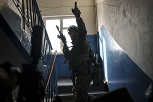 File - Security Service of Ukraine (SBU) servicemen enter a building during an operation to arrest suspected Russian collaborators in Kharkiv, Ukraine, Thursday, April 14, 2022.