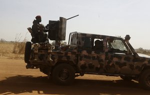 Nigerian soldiers drive past Government Science secondary school in Kankara, Nigeria, Wednesday, Dec. 16, 2020