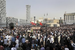 Mourners attend the funeral ceremony of Iran's Revolutionary Guard Col. Hassan Sayyad Khodaei who was killed on Sunday, as a truck carries his flag draped coffin, in Tehran, Iran, Tuesday, May 24, 2022.