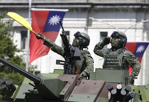 In this Oct. 10, 2021, file photo, Taiwanese soldiers salute during National Day celebrations in front of the Presidential Building in Taipei, Taiwan