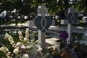 Messages are written on a cross honoring Irma Garcia, a teacher who was killed in this week's elementary school shooting, in Uvalde, Texas, Thursday, May 26, 2022.