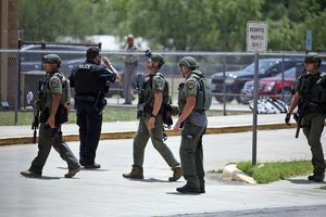 Law enforcement personnel stand outside Robb Elementary School following a shooting, Tuesday, May 24, 2022, in Uvalde, Texas