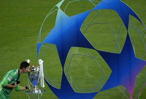 Real Madrid's goalkeeper Thibaut Courtois kiss the trophy after winning the Champions League final soccer match between Liverpool and Real Madrid at the Stade de France in Saint Denis near Paris, Saturday, May 28, 2022