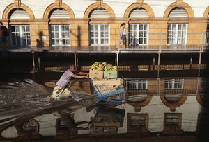 A man pushes a shopping cart loaded with bananas through a street flooded by the Negro River in downtown Manaus, Amazonas state, Brazil, June 1, 2021