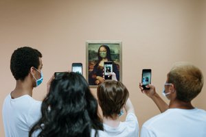 Group of people with surgical face mask taking a group selfie in front of Mona Lisa portrait