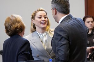 Actor Amber Heard talks with her legal team including Elaine Bredehoft, left, and Benjamin Rottenborn, right, in the courtroom at the Fairfax County Circuit Courthouse in Fairfax, Va., Friday, May 27, 2022