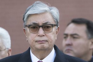 Kazakhstan's interim President Kassym-Jomart Tokayev, center, attends a wreath laying ceremony