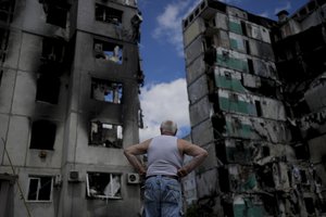 A man stands looking at a building destroyed during attacks, in Borodyanka, on the outskirts of Kyiv, Ukraine, Saturday, June 4, 2022.