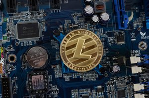 Cryptocurrency Litecoin crypto currency silver coin on hardware computer chip motherboard