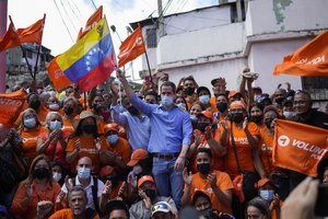 Venezuela opposition leader Juan Guaido poses for a group photo with residents after presenting his his unity plan for Venezuelans, in Maiquetia, Venezuela, Saturday, Feb. 19, 2022.