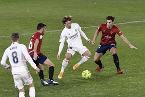 Luka Modric, centre, controls the ball during a Spanish La Liga soccer match between Osasuna and Real Madrid