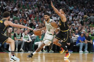 Boston Celtics forward Jayson Tatum (0) drives against Golden State Warriors guard Stephen Curry (30) during Game 3 of basketball's NBA Finals, Wednesday, June 8, 2022, in Boston