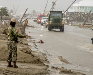 GRAND ISLE, La. (Sept. 16, 2021) Equipment Operator 2nd Class Victoria Witherspoon assigned to Naval Mobile Construction Battalion (NMCB) 133 serves as a ground guide to Mark-30 dump truck operator Equipment Operator 3rd Class Micah Slicer to assist with road clearing operations during Hurricane Ida disaster relief efforts in Grand Isle, La.