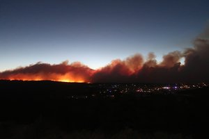 A wildfire burning on the outskirts of Flagstaff, Ariz., casts a glow above neighborhoods on Sunday, June 12, 2022. Evacuations have been ordered for homes in the area.