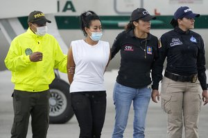 A handcuffed Marisol Londono Bedoya is escorted by police after deplaning at an airport in Bogota, Colombia, Wednesday, June 8, 2022