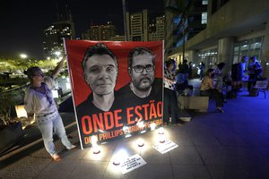 Employees of the National Indigenous Foundation, FUNAI, display a large poster with images of British journalist Dom Phillips, left, and Indigenous affairs expert Bruno Araujo Pereira, and with the Portuguese phrase "Where they are?" during a vigil in Brasilia, Brazil, Thursday, June 9, 2022