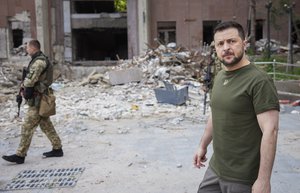 In this photo provided by the Ukrainian Presidential Press Office on Saturday, June 18, 2022, Ukrainian President Volodymyr Zelenskyy inspects damaged buildings as he visits the war-hit Mykolaiv region.