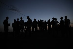 FILE - Tigrayan refugees who fled the conflict in the Ethiopia's Tigray gather after the sun sets in Hamdayet, eastern Sudan, near the border with Ethiopia, on March 23, 2021.