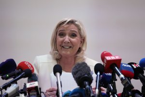 French far-right leader Marine Le Pen smiles during a press conference in Paris, Wednesday, April 13, 2022