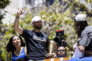 Golden State Warriors' Stephen Curry gestures as he holds the MVP trophy during the NBA Championship parade in San Francisco, Monday, June 20, 2022, in San Francisco. (AP Photo/John Hefti)