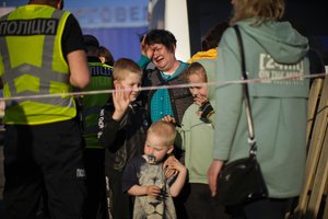 File - Luda Lobanova, 58, center, cries next to her three grandchildren as they arrive to a reception center for displaced people in Zaporizhzhia, Ukraine, Sunday, May 8, 2022. Volunteer drivers are risking everything to deliver humanitarian aid to Ukrainians behind the front lines of the war.