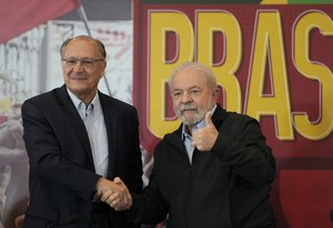 Brazil's former president who is running for reelection, Luiz Inacio Lula da Silva, right, shakes hands with his running-mate Geraldo Alckmin and gives a thumbs up during the launch of their government plan in Sao Paulo, Brazil, Tuesday, June 21, 2022.