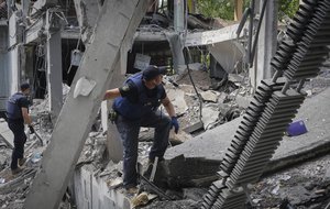 Ukrainian Emergency Situations Ministry employees search the site of a bombing in the school where a graduation ceremony, called the Last School Bell, was supposed to take place in Kharkiv, Ukraine, Thursday, June 2, 2022.