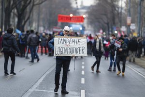 A person with a sign during a demonstration against measures to battle the coronavirus pandemic in Vienna, Austria, Saturday, Dec. 11, 2021