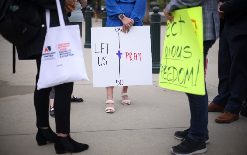 A woman holds a sign that says 