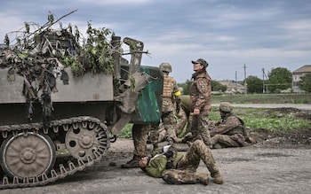 Ukrainian troops assist their comrades near the front line in the eastern Ukraine region of Donbas, which is now the focus of the war