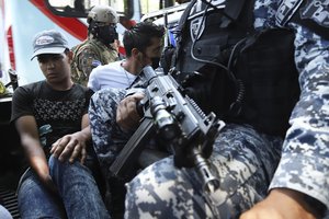 File - Men are detained by the police, suspects in a homicide near a market in San Salvador, El Salvador, Sunday, March 27, 2022. El Salvador's congress has granted President Nayib Bukele request to declare a state of emergency, amid a wave of gang-related killings over the weekend