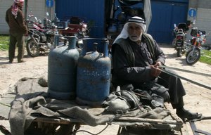 File - An elderly Palestinian waits to fill his empty gas canisters outside a fuel station in the southern Gaza Strip town of Khan Younis. The blockade of the Gaza Strip, made permanent in 2007, has been criticised by the United Nations Human Rights Council (UNHRC) and other human rights organizations.