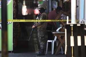 A Salvadoran army soldier guards the perimeter of a homicide in public toilets in a small market in San Salvador, El Salvador, Sunday, March 27, 2022.The government of President Bukele authorized the Suspension of Rights and Freedoms in a decree approved by the Legislative Assembly to neutralize criminal groups related to the killings.