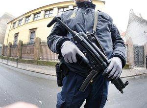 A Danish police officer stands outside of a synagogue, Sunday, Feb. 15, 2015, where a gunman opened fire in Copenhagen, Denmark.