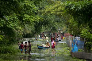 Flood-affected people move towards safer grounds from marooned Tarabari village, west of Gauhati, in the northeastern Indian state of Assam, Monday, June 20, 2022.