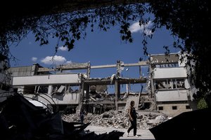 Ukrainian journalists walk in the yard of National Pedagogic university destroyed by a Russian attack in Kharkiv, Ukraine, Wednesday, July 6, 2022.