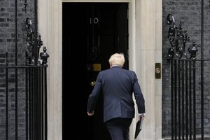 Prime Minister Boris Johnson walks back inside after reading a statement outside 10 Downing Street, London, formally resigning as Conservative Party leader, in London, Thursday, July 7, 2022.