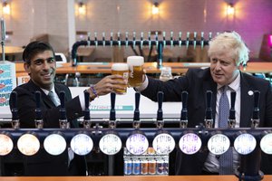 Britain's Prime Minister Boris Johnson, right, with Chancellor of the Exchequer Rishi Sunak during a visit to Fourpure Brewery in London, Wednesday, Oct. 27, 2021, after Sunak delivered his Budget to the House of Commons.