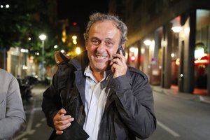 Michel Platini makes a phone call after being freed, outside the French police anti-corruption and financial crimes office in Nanterre, outside Paris, early Wednesday, June 19, 2019