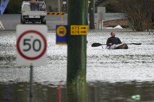 A man paddles his kayak through a flooded street at Windsor on the outskirts of Sydney, Australia, Tuesday, July 5, 2022. Hundreds of homes have been inundated in and around Australia's largest city in a flood emergency that was impacting 50,000 people, officials said Tuesday.