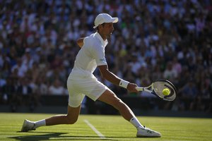 Serbia's Novak Djokovic returns to Britain's Cameron Norrie in a men's singles semifinal on day twelve of the Wimbledon tennis championships in London, Friday, July 8, 2022.