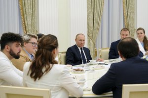 Russian President Vladimir Putin, center, speaks to winners of the Leaders of Russia Competition, the flagship project of the Russia - Land of Opportunity presidential platform in the Kremlin in Moscow, Russia, Thursday, July 7, 2022.