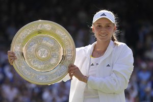 Kazakhstan's Elena Rybakina holds the trophy as she celebrates after beating Tunisia's Ons Jabeur to win the final of the women's singles on day thirteen of the Wimbledon tennis championships in London, Saturday, July 9, 2022