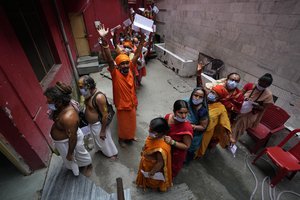 Hindu pilgrims, some chanting religious slogans, line up to register for an annual pilgrimage to the holy Amarnath cave, in Jammu, India, Saturday, July 9, 2022