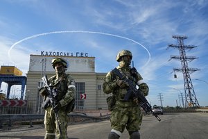 FILE - Russian troops guard an entrance of the Kakhovka Hydroelectric Station, a run-of-river power plant on the Dnieper River in Kherson region, south Ukraine, Friday, May 20, 2022. The Kherson region has been under control of the Russian forces since the early days of the Russian military action in Ukraine. This photo was taken during a trip organized by the Russian Ministry of Defense. (AP Photo, File)