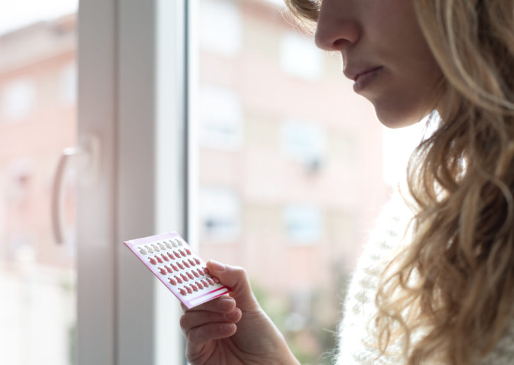 Photo: Close-up image of woman holding birth control pills in a package