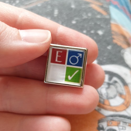 A square enamel pin badge showing the AO3 symbols for male couple, explicit, finished fic, and no archive warnings apply