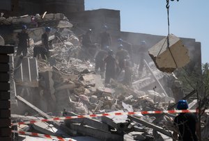 Ukrainian State Emergency Service firefighters clear debris at a damaged residential building in the town of Serhiivka, located about 50 kilometers (31 miles) southwest of Odesa, Ukraine, Saturday, July 2, 2022