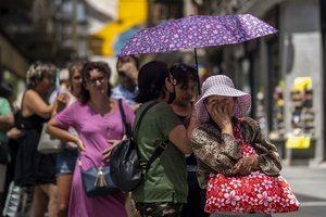 A woman queues to buy tickets of lottery during a hot and sunny day in Madrid, Spain, Monday, July 18, 2022