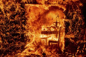 Flames engulf a chair inside a burning home as the Oak Fire burns in Mariposa County, Calif., on Saturday, July 23, 2022.